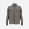 Gray long-sleeve button-up shirt with a collar and two front chest pockets on a plain background.