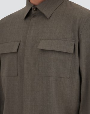 Close-up of a brown utility shirt with two flap pockets on the chest and a pointed collar.