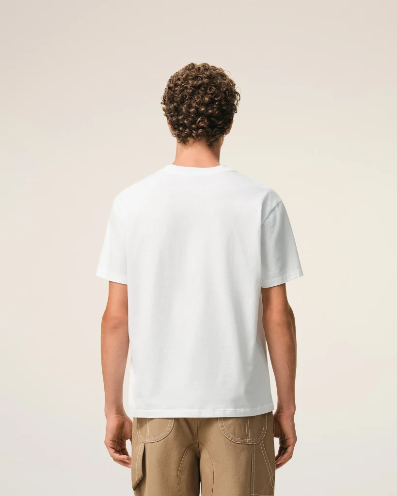 Back view of a person wearing a white t-shirt and tan cargo pants against a neutral beige background.