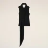 Black sleeveless top with a long scarf draped around the neck, hanging down the front against a beige background.