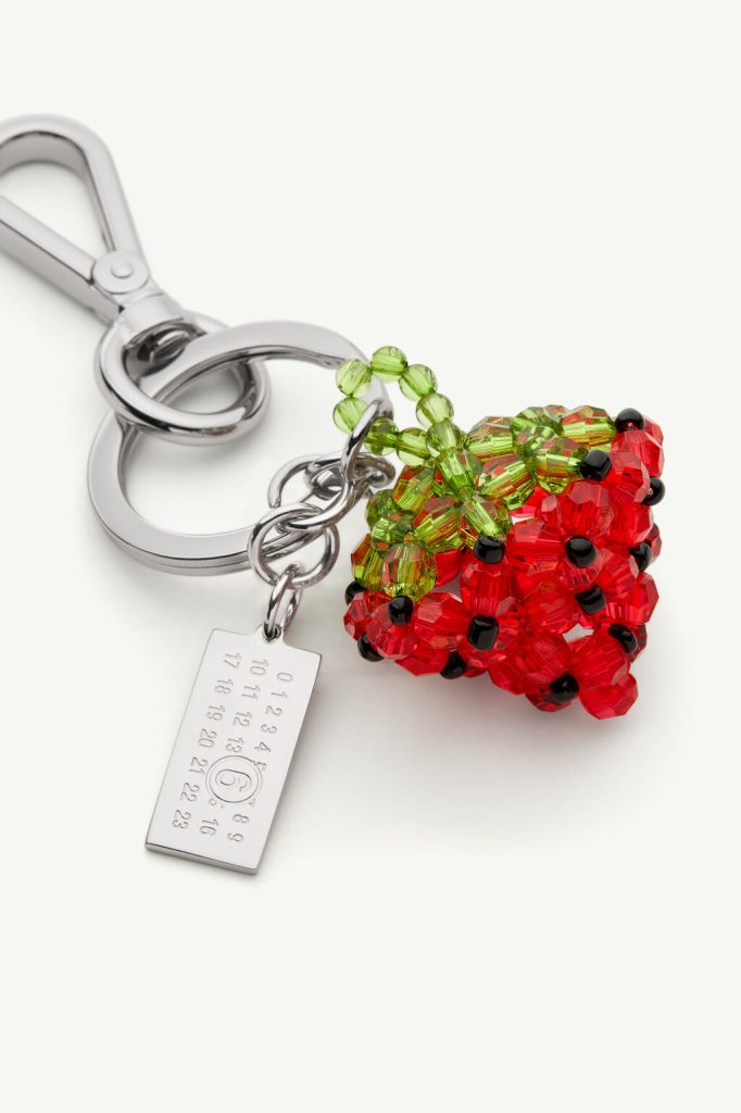 Beaded raspberry-shaped keychain with red beads and green leaf beads on a silver ring and tag accessory.