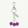 Metal keychain with three purple bead flowers on green beaded stems and a silver clip attachment.