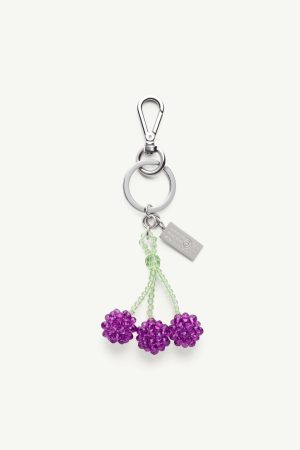 Metal keychain with three purple bead flowers on green beaded stems and a silver clip attachment.