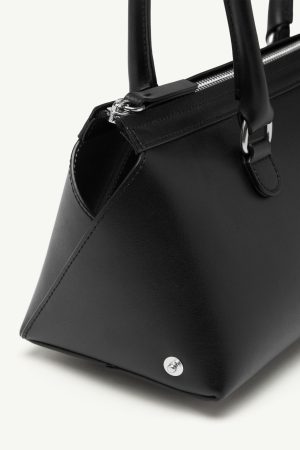 Close-up of a black leather handbag with silver zip and hardware, showing the bottom corner and a metal stud.