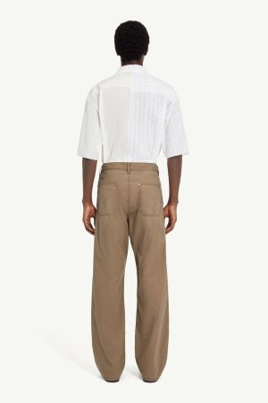 Back view of a person wearing a white short-sleeve shirt and tan wide-leg pants.