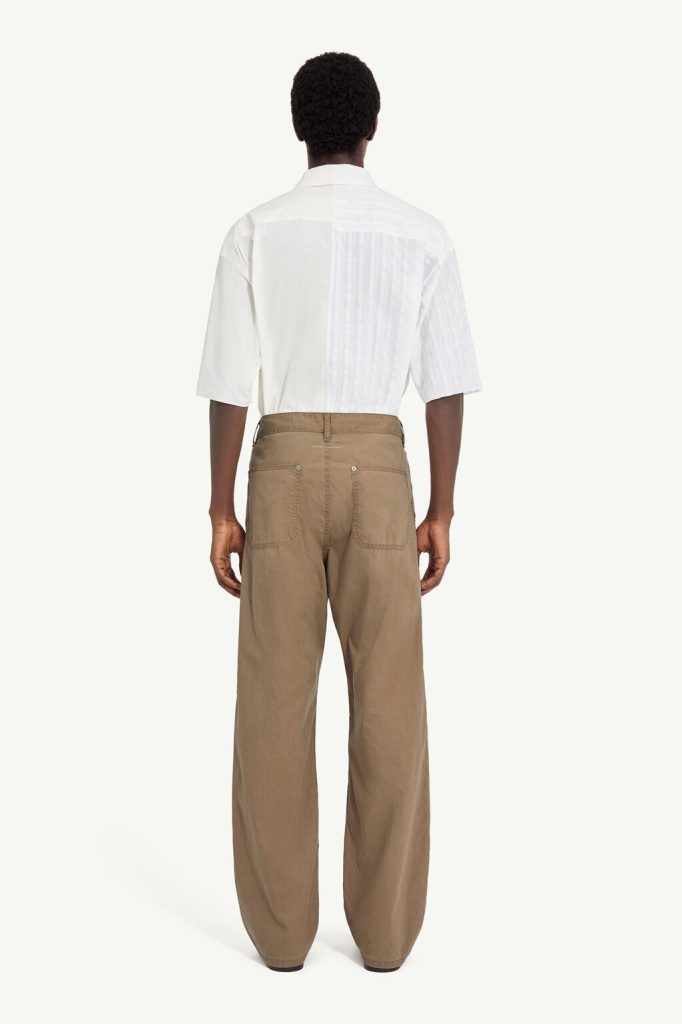 Back view of a person wearing a white short-sleeve shirt and tan wide-leg pants.