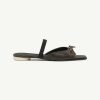 Dark brown leather slide sandal with an open toe, back strap, and a small bow knot at the front over a light-colored sole.