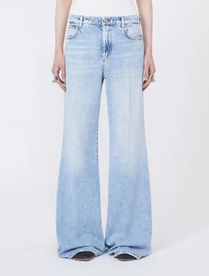 Full-length, light-wash wide-leg denim jeans on a model with a white top in a neutral studio setting.