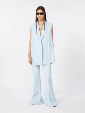 Model wearing a light blue sleeveless blazer and matching wide-leg pants with sunglasses.