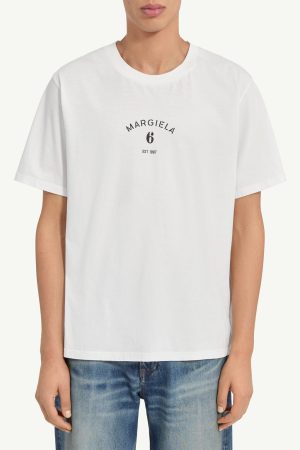White short-sleeve T-shirt with a small black circular Margiela 6 logo on the chest, worn by a model.