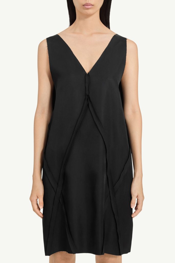 Black sleeveless dress with a deep V-neck and wrapped, overlapping front panels reaching knee length.