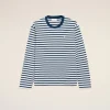 Striped navy and white long-sleeve shirt displayed against a light beige background, chest logo subtly visible.