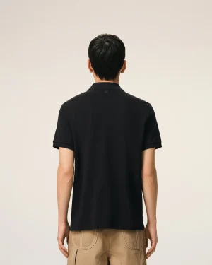 Back view of a person wearing a black polo shirt and tan pants, showing the shirt’s collar and back pockets stitching unmistakable in view beneath a plain background.