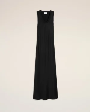 Long black sleeveless dress with a deep V-neck displayed against a pale beige background.
