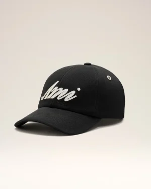 Black baseball cap with white cursive lettering on the front panel, photographed against a light backdrop.