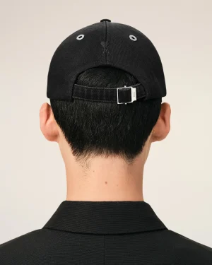 Back of a person’s head wearing a black baseball cap with an adjustable strap visible at the back