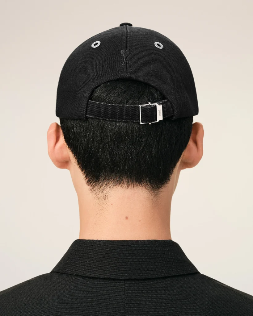 Back of a person’s head wearing a black baseball cap with an adjustable strap visible at the back