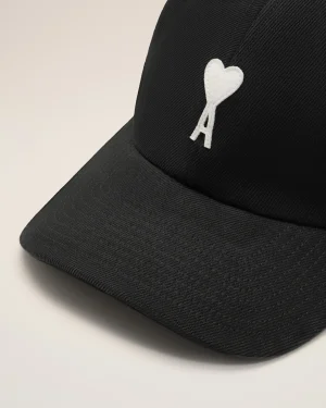 Close-up of a black cap with a white heart-shaped patch embroidered on the front part of the crown.