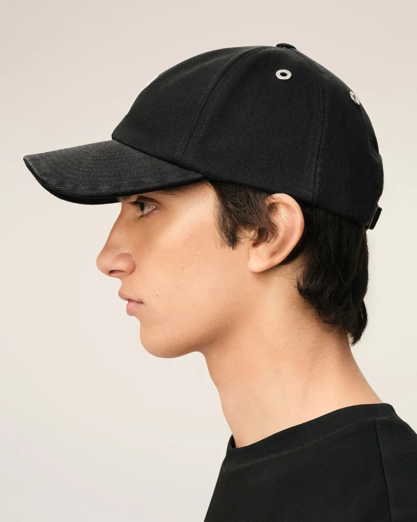 Side profile of a person wearing a black baseball cap, with the curved brim extending to the left.
