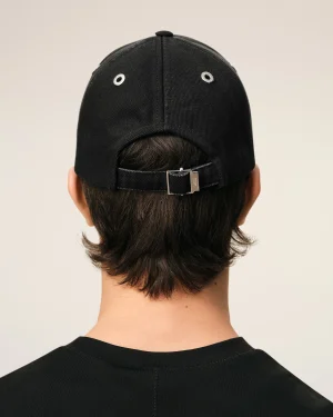 Back view of a person wearing a black baseball cap with metal eyelets and an adjustable strap at the back