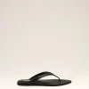 Black flip-flop sandals with a slim thong strap resting on a light beige background.