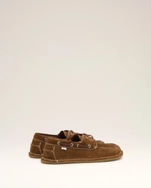 Brown suede boat shoes with white stitching and laces on a pale background.