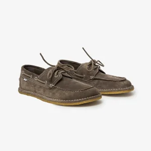 Pair of brown suede boat shoes with white stitching and laces, displayed on a light background.