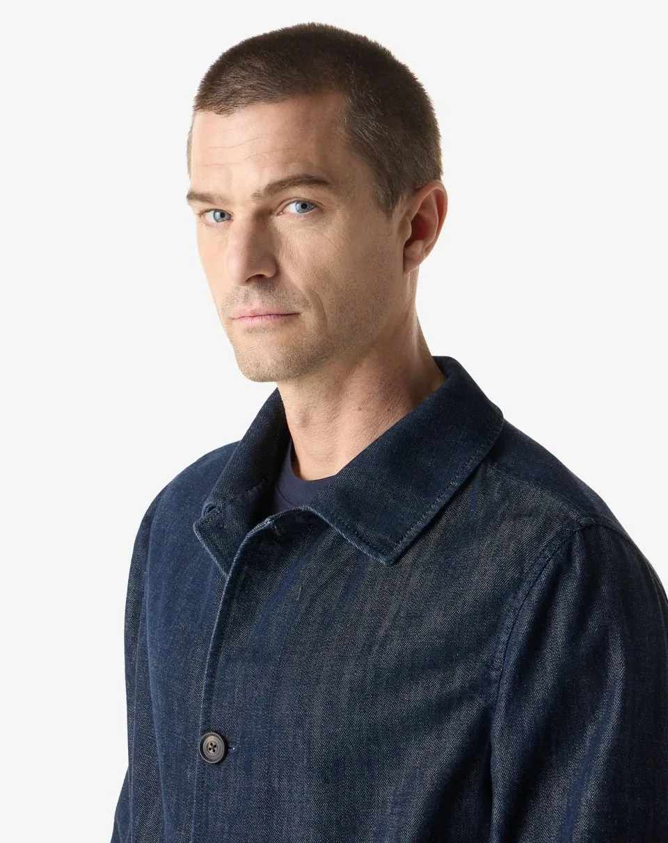 IMG_1579 - New Trend Portrait of a man with short dark hair wearing a dark denim jacket against a white background, looking slightly to the left.