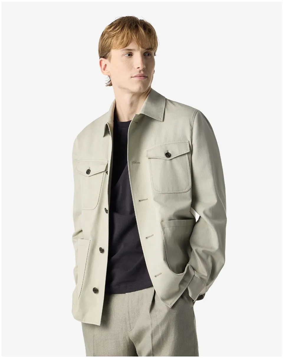 IMG_1581 - New Trend Young man wearing a light beige jacket over a black shirt, with hands in pockets, looking to the right, on a white background.