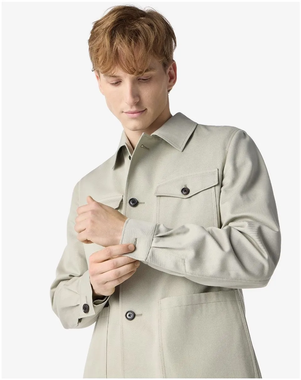 IMG_1583 - New Trend Young man in a light beige trench coat adjusting the cuff on his sleeve.