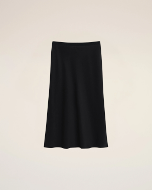 A black knee-length skirt with a ribbed elastic waistband against a light beige background.