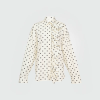 Untitled design - New Trend Cream polka-dot blouse with a ruffled front and button placket along the left side.