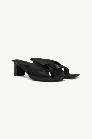 Black leather open-toe sandals with chunky block heel and wide straps, side view on white background.