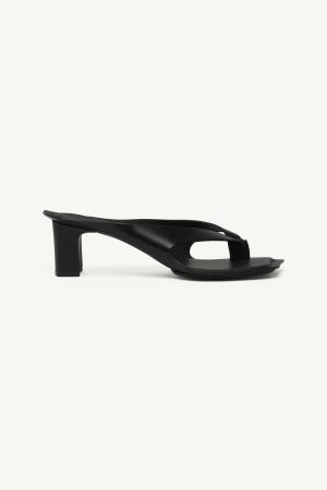 Black leather thong sandal with a chunky mid-height block heel and minimalist curved strap design