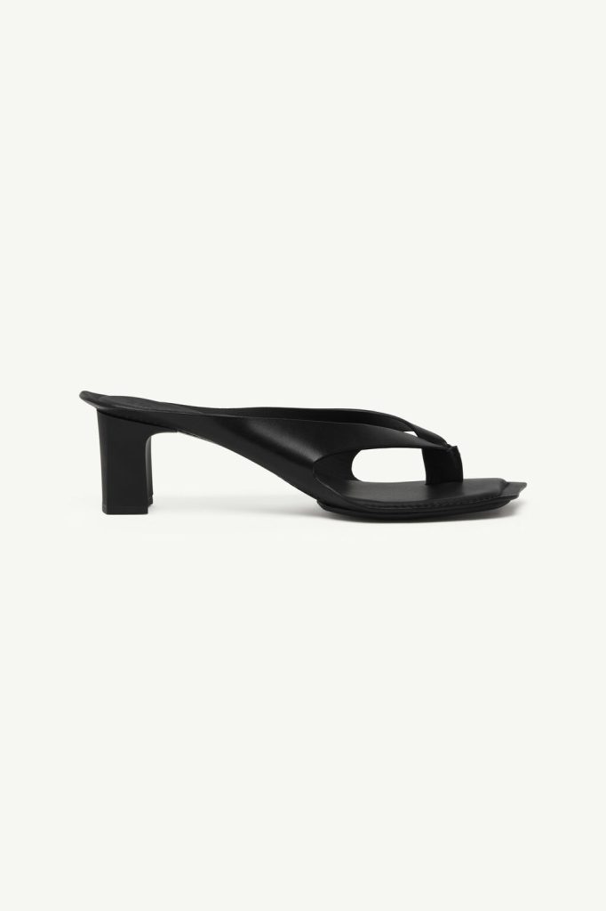 Black leather thong sandal with a chunky mid-height block heel and minimalist curved strap design