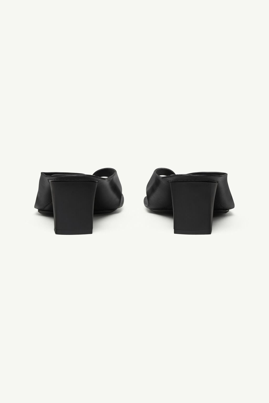 IMG_1220 - New Trend Pair of black heeled mules seen from behind, featuring chunky square heels and open backs.