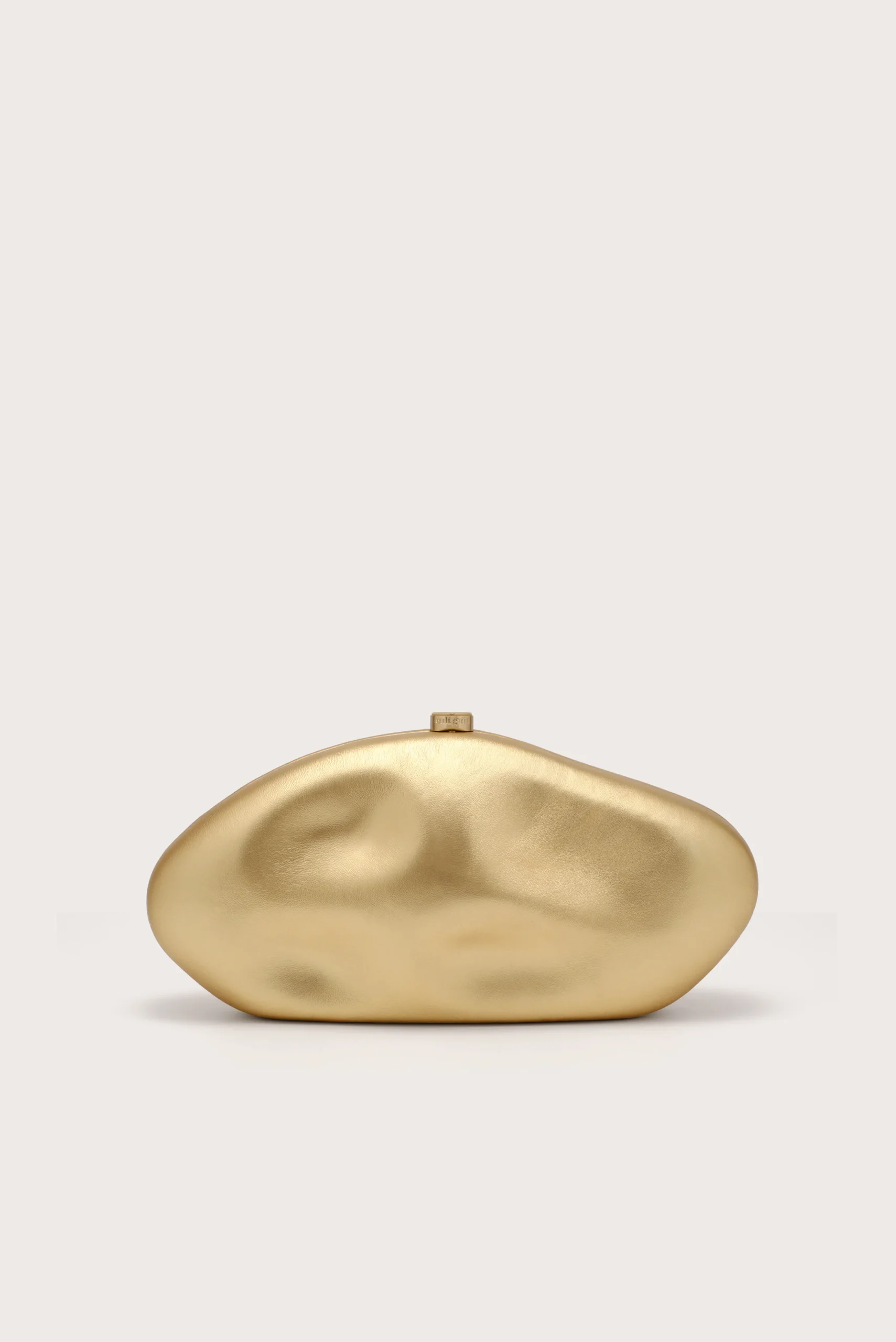 IMG_1262 - New Trend Gold-toned, abstract organic sculpture on a light beige background with soft shadows.