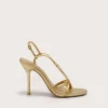 IMG_1271 - New Trend Gold strappy high-heeled sandal shown from a side angle with stiletto heel on a light background, partial view of the shoe close to bottom left