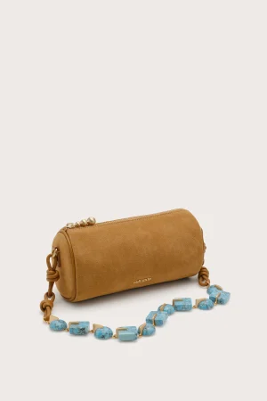 Tan suede crossbody bag with gold zipper and chain strap, shown with turquoise beaded necklace nearby.