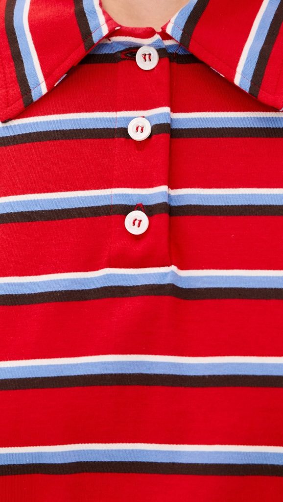 Close-up of a red striped polo shirt with white buttons and blue, white, and black horizontal stripes