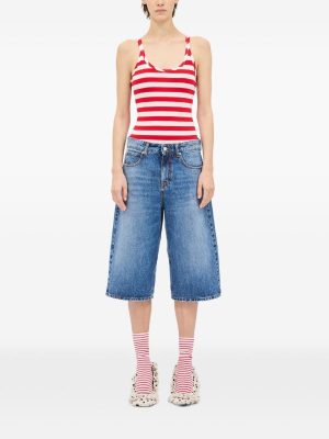 Model wearing a red-and-white striped tank top with blue denim Bermuda shorts, pink-and-white striped socks, and white sneakers.