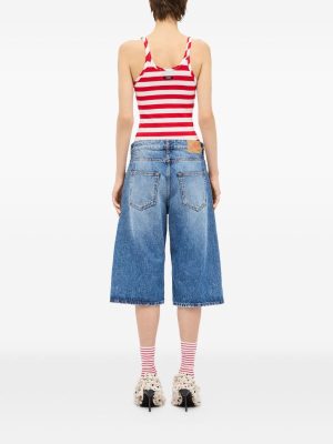 Back view of a model wearing a red-and-white striped tank top, knee-length wide denim shorts, striped socks, and fluffy-sole sandals.