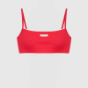 Red spaghetti-strap bikini top on a white mannequin, front view with a small label at the center.