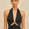 IMG_1384 - New Trend Model wearing a black halter top with a front knot and gold hardware against a beige backdrop, posed for a fashion shoot jaw-length portrait.