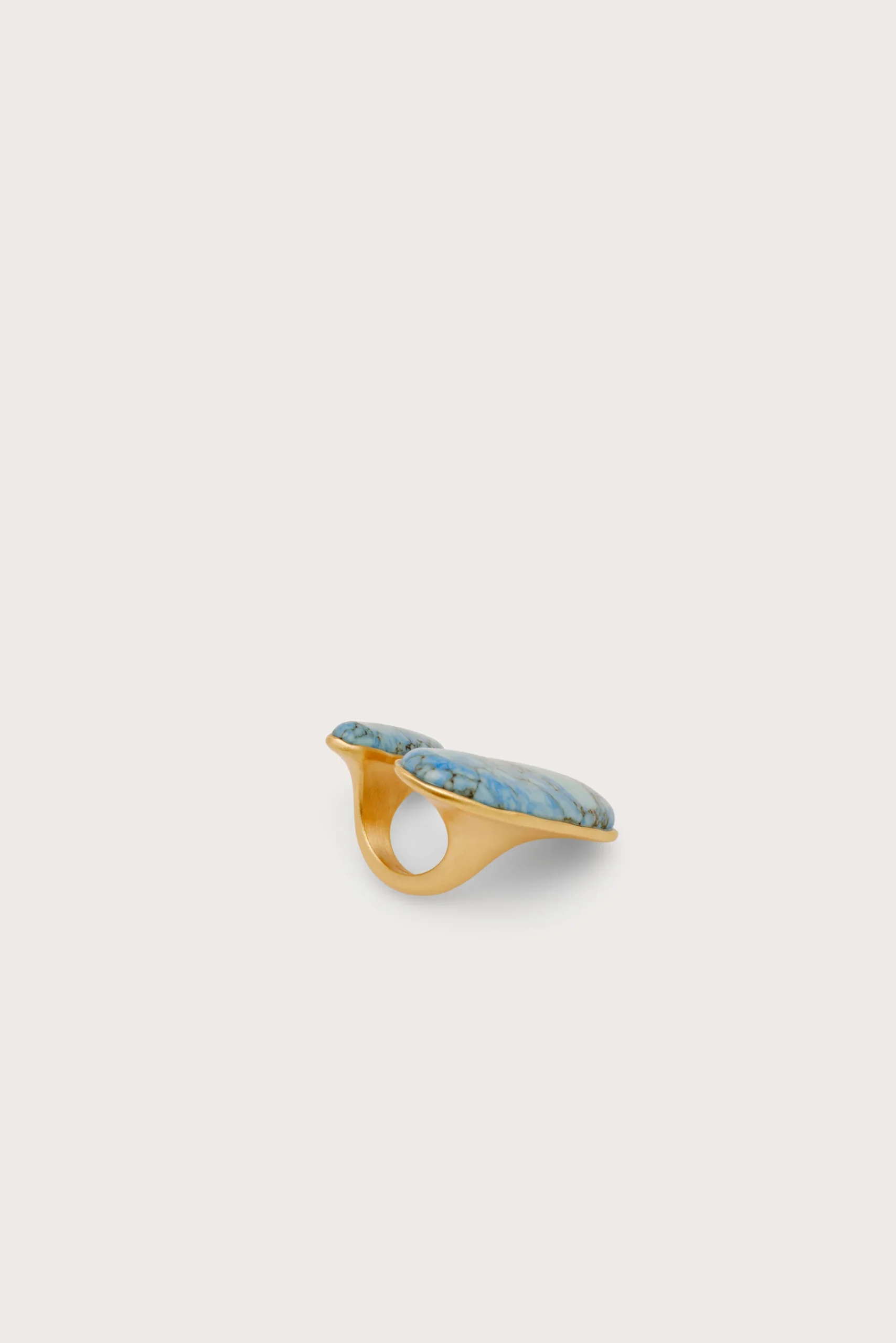 IMG_1426 - New Trend Gold-toned open cuff bracelet featuring two turquoise stones set along the top edge, shown at an angle on a light background.