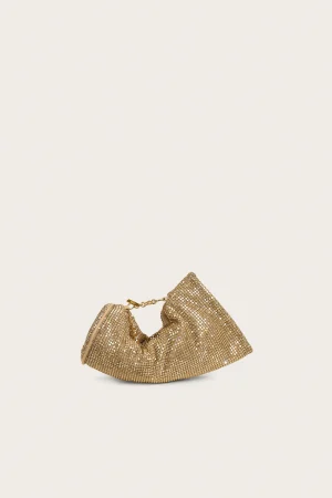 Gold sequined clutch purse with chain strap on a light beige background