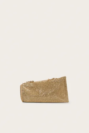 Gold sequined clutch bag with a short chain strap resting on a pale beige background.
