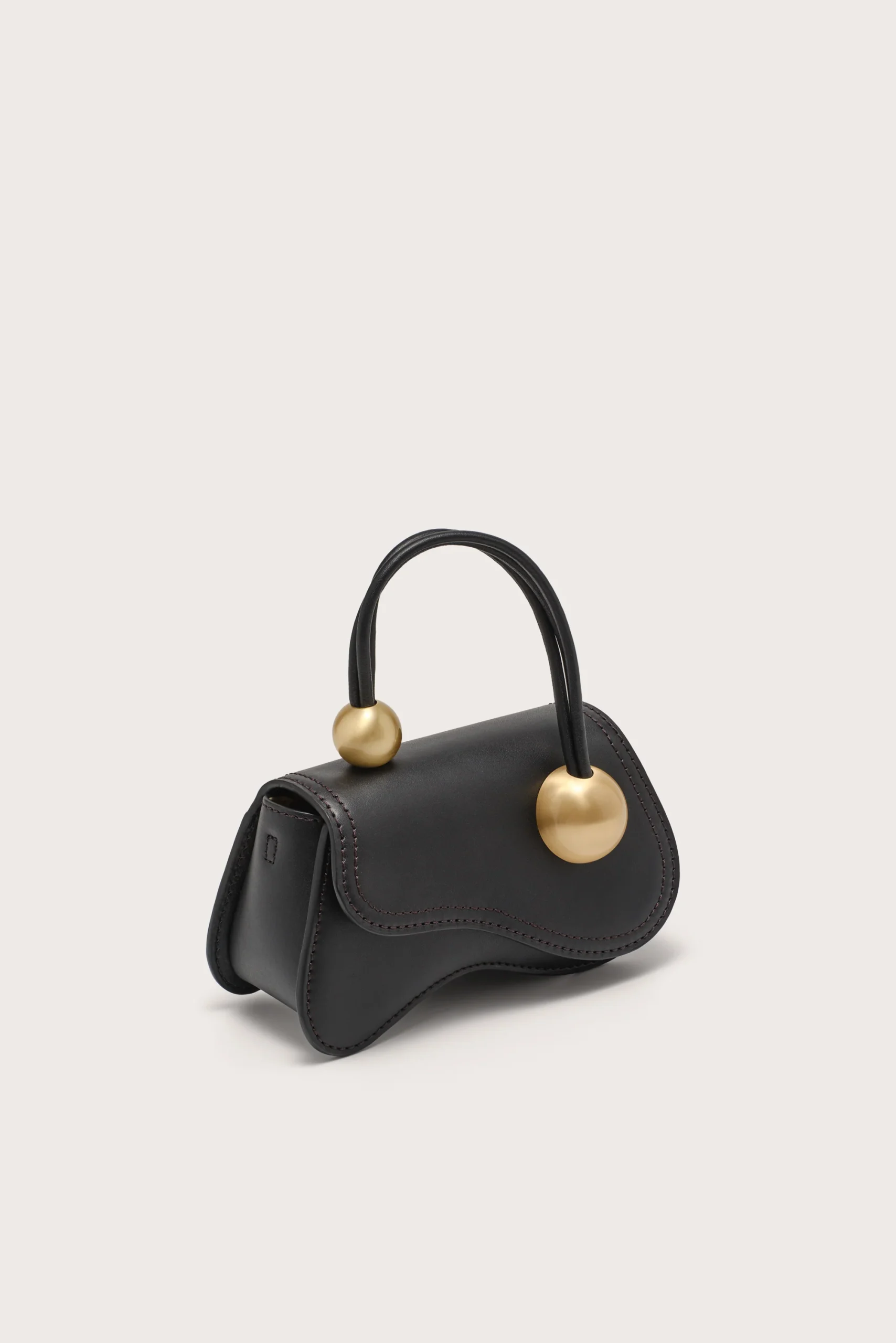 IMG_1569 - New Trend Black structured handbag with two gold spherical handles on a light background.