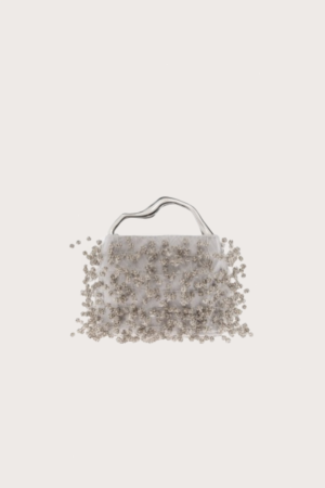 White beaded handbag with a curved metal handle against a pale background.