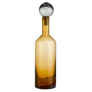 Amber glass decanter with a round glass stopper at the top, empty.